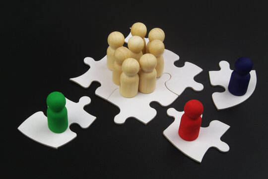 Hire remote employees, team building, teamwork concept. Colorful people figures on single puzzles as remote worker and many figures standing together as office. 