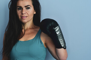 Portrait  of Smiling  young Beautiful  sports woman posing  putting hands together in Boxing Gloves isolated  on grey background