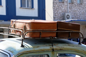 Old suitcases on a roof rack of a car