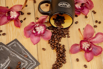 Scattered coffee beans. a cup of black coffee, espresso. orchid flowers. Traditional hospitality and care. (the inscription on the "coffee" on the mug. the inscription on the napkin "Bon appetit").
