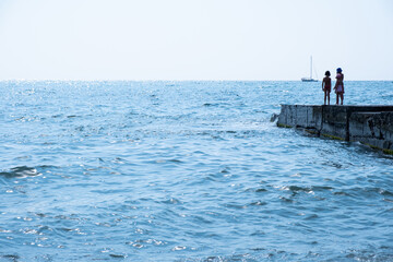 Several unrecognizable children away on the pier. sea view