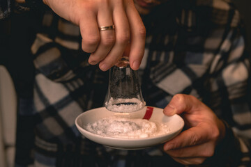 Bartender dipping shot glass in salt preparing for serving of tequila