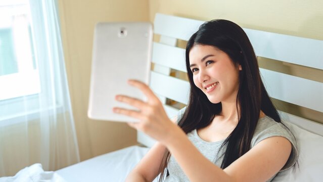 Portrait asian woman using smartphone taking a selfie work from home, Technology communication lifestyles concept.