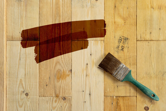 Brown paint with paintbrush on wood background