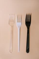 Disposable plastic cutlery on peach background