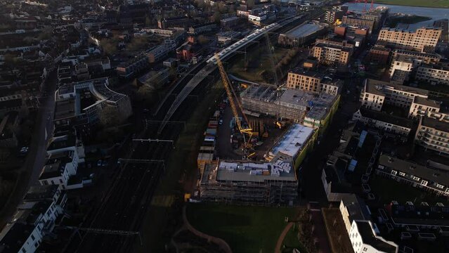 Approach and aerial pan showing Ubuntuplein construction site in urban development of real estate investment project in new Noorderhaven neighbourhood. Housing shortage and engineering concept.