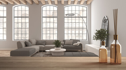 Wooden table top or shelf with aromatic sticks bottles over modern living room with large sofa and big windows, modern architecture interior design