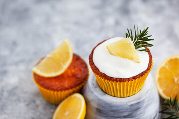 Homemade delicious lemon cupcakes, decorated with creamcheese and fresh citrus fruits