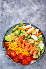 Delicious fresh salad with prawns, avocado, eggs, bell pepper, tomatoes and herbs