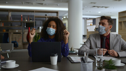 Fototapeta na wymiar Business team wearing masks discuss corporate strategy in coronavirus pandemic.