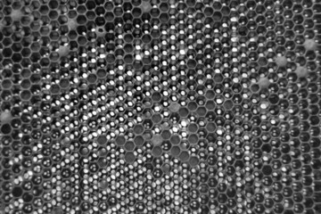 Drop of bee honey drip from hexagonal honeycombs
