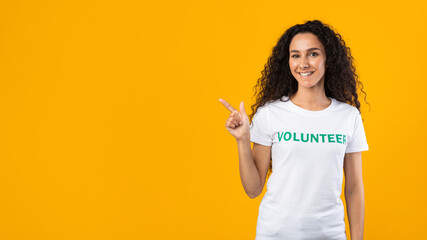 Volunteer Lady Pointing Finger At Free Space, Yellow Background, Panorama