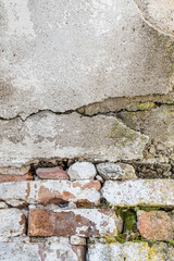 An old brick wall with fallen plaster. Green moss on a brick wall. Vintage texture.