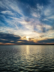 Sunset over a pond with trees in the foreground, forest on the opposite Bank. Russia. Udmurtia.