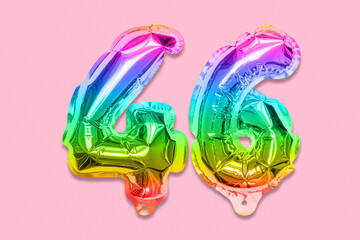 Rainbow foil balloon number, digit forty six on a pink background. Birthday greeting card with inscription 46. Anniversary concept. Top view. Numerical digit. Celebration event, template.