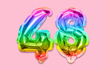 Rainbow foil balloon number, digit forty eight on a pink background. Birthday greeting card with inscription 48. Top view. Numerical digit. Celebration event, template.