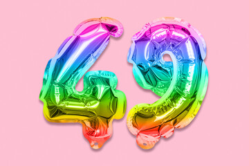 Rainbow foil balloon number, digit forty nine on a pink background. Birthday greeting card with inscription 49. Top view. Numerical digit. Celebration event, template.