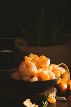 Juicy tangerines falling on dark backgorund