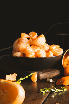 Juicy tangerines falling on dark backgorund