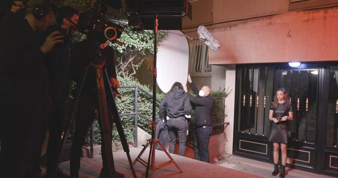 Behind The Scenes Shot Of Production Team Shooting A Scene With Professional Actress Outdoor During Nighttime. wide