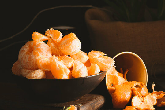 Juicy tangerines falling on dark backgorund