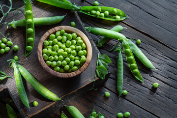 Green peas and pea pods on wooden table. Top view.