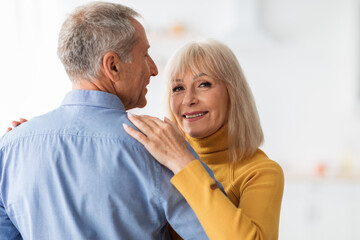 Senior Wife Dancing With Husband Smiling To Camera At Home