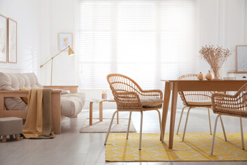 Dining room interior with wooden table and wicker chairs