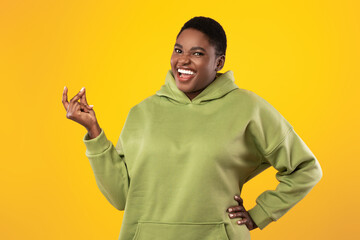 Happy Oversized African American Lady Snapping Fingers Over Yellow Background