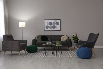 Stylish comfortable poufs and sofa in room. Home design