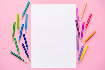 multi-colored felt-tip pens on a pink background, space for text, top view, blank sheet