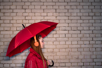 young girl with a red umbrella and headphones