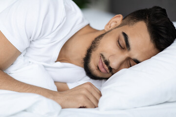 Obraz na płótnie Canvas Closeup Shot Of Handsome Young Arab Man Sleeping In Comfortable Bed