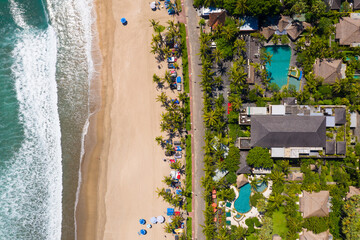 Top down view of the famous Kuta beach in Seminyak in southern Bali with luxury seafront resort in Indonesia