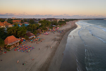 Aerial view of the sunset over the famous Seminyak beach with beach bars in Kuta in south Bali in Indonesia