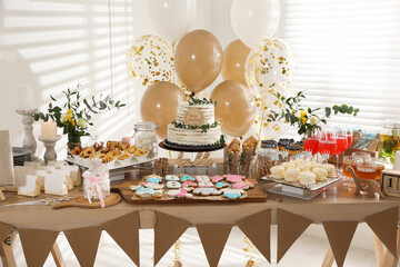 Baby shower party. Different delicious treats on wooden table and decor indoors