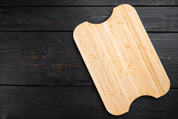 Bamboo kitchen cutting board empty for empty for copy space for text or food, top view flat lay , on black wooden table background