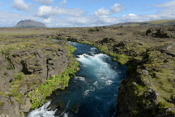 Fototapeta na wymiar Kleiner Bach fließt durch ein Lavafeld bei Hella nahe dem Vulkan Hekla in Island