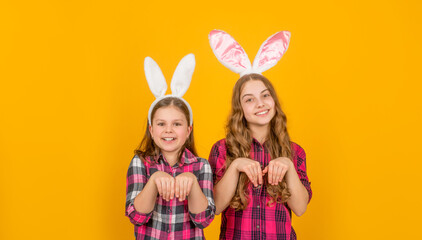 Obraz na płótnie Canvas funny positive easter children in bunny ears on yellow background