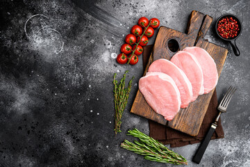 Raw pork steak meat, on black dark stone table background, top view flat lay, with copy space for...