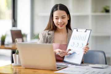 Portrait of an Asian young businesswoman working on a laptop computer in her workstation.Asian young Business people employee freelance online marketing Report e-commerce telemarketing concept.