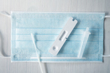 2019 ncov home antigen test card kit laying on blue facemask.