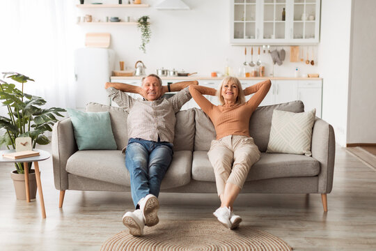 Happy Mature Couple Sitting On Couch Relaxing Resting At Home