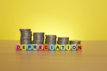 DEPRECIATION words on colorful cubes with coins stacked at the back 