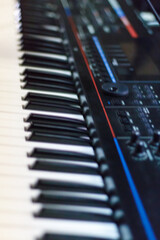 Close up of synthesizer keys on a blurred background. Musical keyboard synthesizer. Defocus. Piano board, USB keyboard, music background.