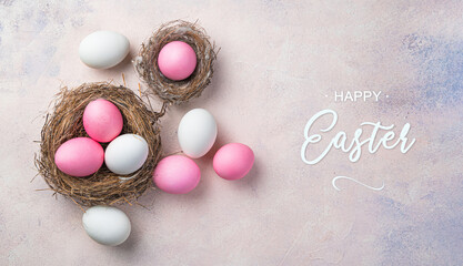 Happy Easter, colored pink and white eggs in nests on a delicate pink background.