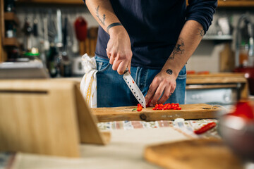 close up of man cutting red paprika