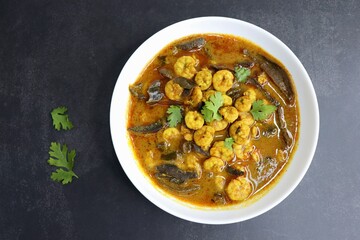 Tangy and spicy Shrimp curry. Tiny prawns curry made using dried mango and Indian spices. garnished with coriander and served with cucumber slices. Copy space.