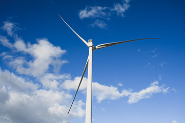 Wind turbine. Wind farm against blue sky. Wind turbines on the hill. Producing electric energy. Renewable energy. Wind park.