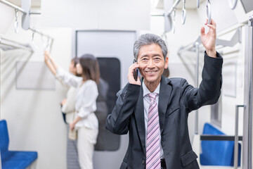 電車内で通話をするビジネスマン